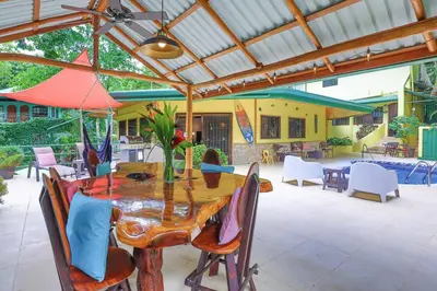 a wooden table with chairs and an umbrella on a patio at Jungle Creek, Casita Colibri, Studio with Big Patio in Quepos