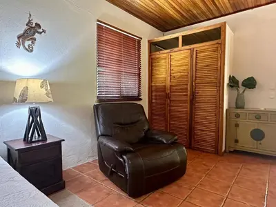 a bedroom with a leather chair and a bed at Jungle Creek, Casita Colibri, Studio with Big Patio in Quepos
