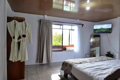 a bedroom with a bed and a window at Volcano & Lake Arenal View Suite with Soaking tub in El Castillo de La Fortuna