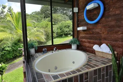 a bath tub in a bathroom with a window at Volcano & Lake Arenal View Suite with Soaking tub in El Castillo de La Fortuna