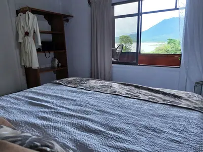 a bedroom with a bed and a window with a view at Volcano & Lake Arenal View Suite with Soaking tub in El Castillo de La Fortuna