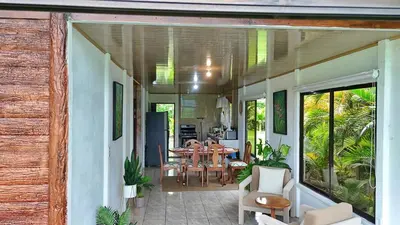 a house with a porch with a table and chairs at Volcano & Lake Arenal View Suite with Soaking tub in El Castillo de La Fortuna