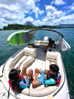 a group of people sitting on a boat in the water at Volcano & Lake Arenal View Suite with Soaking tub in El Castillo de La Fortuna