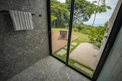 a glass door leading to a patio with a chair at NEW - Private Villa - Highest Point Manuel Antonio in Manuel Antonio