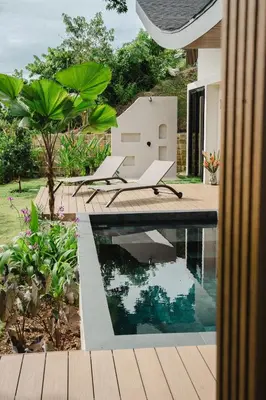 a swimming pool with two chairs next to a house at NEW - Private Villa - Highest Point Manuel Antonio in Manuel Antonio