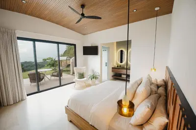 a bedroom with a large bed and a balcony at NEW - 360 Private Oasis - Ocean & Jungle Views in Manuel Antonio