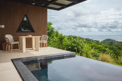 a house with a swimming pool and a table and chairs at NEW - 360 Private Oasis - Ocean & Jungle Views in Manuel Antonio