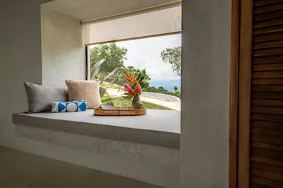 a window seat with flowers in a room at NEW - 360 Private Oasis - Ocean & Jungle Views in Manuel Antonio