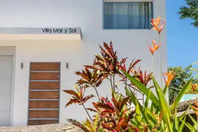 a door of a white building with a sign on it at Tortuga, 1BR Apartment in Villa Mar y Sol, Pool, Big Deck, and Wildlife in Manuel Antonio