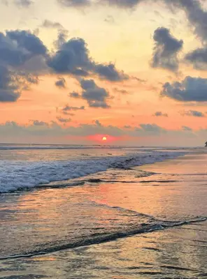 a sunset on the beach with the ocean at Costa Rica Beach Bungalow in Playa Hermosa