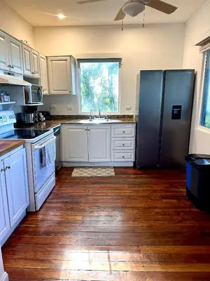 a kitchen with white cabinets and a stainless steel refrigerator at Costa Rica Beach Bungalow in Playa Hermosa