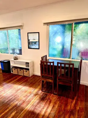 a dining room with a table and chairs and windows at Costa Rica Beach Bungalow in Playa Hermosa