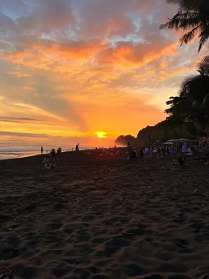 a group of people on a beach at sunset at Costa Rica Beach Bungalow in Playa Hermosa