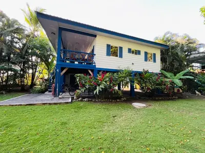 a house with a balcony and a yard at Costa Rica Beach Bungalow in Playa Hermosa
