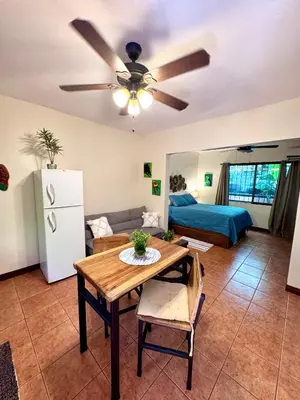 a living room with a ceiling fan and a table at Tiny Paradise Ground Floor Studio in Coco
