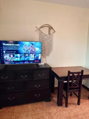 a living room with a table and a tv and a table and a chair at Tiny Paradise Ground Floor Studio in Coco