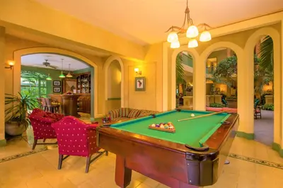 a living room with a pool table and chairs at Hotel Casa Turire in Turrialba