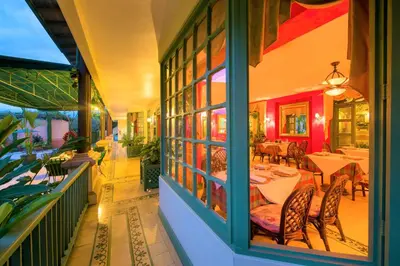 a restaurant with tables and chairs on a balcony at Hotel Casa Turire in Turrialba