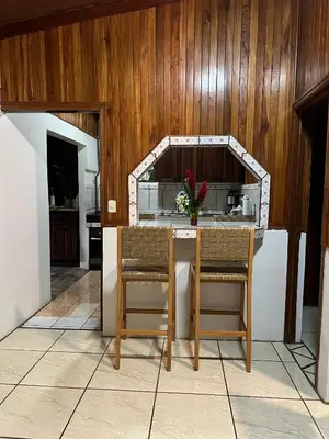 a kitchen with a table with chairs and a counter at Peaceful Jungle Home, River Access, Arenal Views in El Castillo de La Fortuna