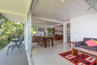 a living room with a couch and a table at Lapa Roja, 2BR Ocean View Apartment in Villa Mar y Sol, Nature in Manuel Antonio