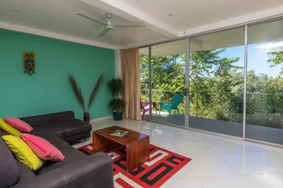 a living room with a couch and a table at Lapa Roja, 2BR Ocean View Apartment in Villa Mar y Sol, Nature in Manuel Antonio