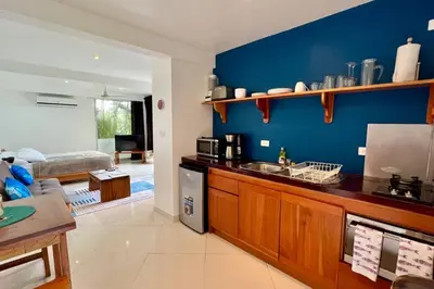 a kitchen with a sink and a blue wall at Mariposa, 1BR Apart in Villa Mar y Sol, Pool, Balcony, and Wildlife in Manuel Antonio