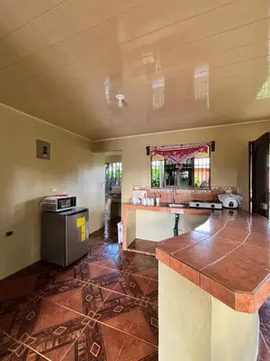 an empty living room with a counter and a table at Cabaña La Conquista in Sarapiquí
