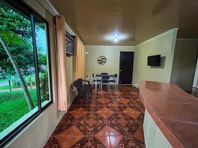 a room with a kitchen with a table and a window at Cabaña La Conquista in Sarapiquí