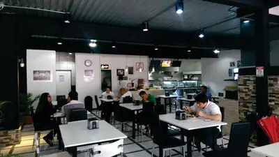 a group of people sitting at tables in a restaurant at Costa Rica Walk in in San José