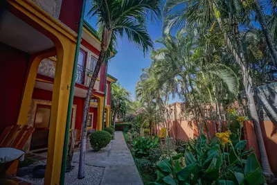 a walkway with palm trees and a building at 2BR Townhome in Tamarindo• Pool • Walk to Beach in Tamarindo