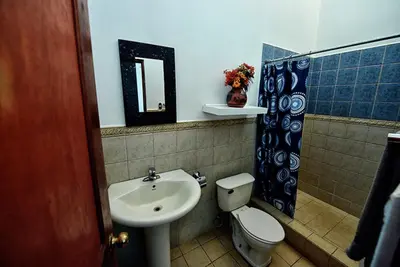 a bathroom with a sink and a toilet and a mirror at 2BR Townhome in Tamarindo• Pool • Walk to Beach in Tamarindo
