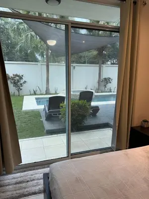 a bedroom with a view of a pool through a window at Beachside 1st Floor Condo Near Flamingo & Conchal in Santa Cruz