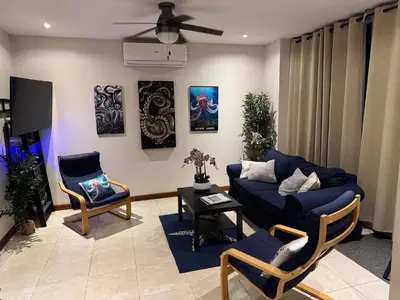a living room with a blue couch and chairs at Beachside 1st Floor Condo Near Flamingo & Conchal in Santa Cruz
