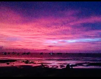 a sunset over the ocean with a pink at Beachside 1st Floor Condo Near Flamingo & Conchal in Santa Cruz