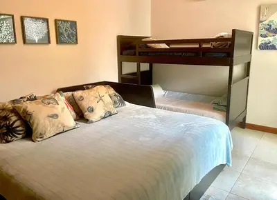 a bedroom with a bed with two bunk beds at Beachside 1st Floor Condo Near Flamingo & Conchal in Santa Cruz