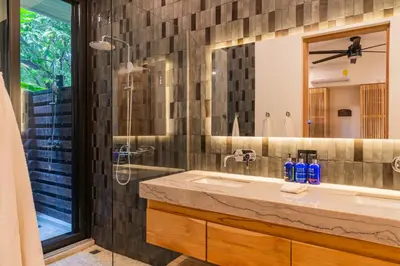 a bathroom with a sink and a shower and a mirror at NEW Modern 6BR, Pool, Walk 2 Beach, Sleeps 20 in Playa Guiones