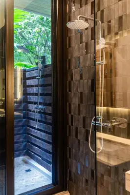 a shower with a glass door in a bathroom at NEW Modern 6BR, Pool, Walk 2 Beach, Sleeps 20 in Playa Guiones