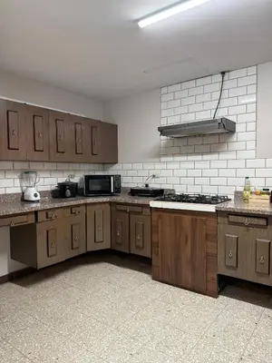 a large kitchen with wooden cabinets and a microwave at Harmony Hotel by Haven in San José