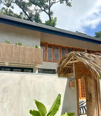 a house with a thatched roof and a fence at Las chozas I in Tamarindo
