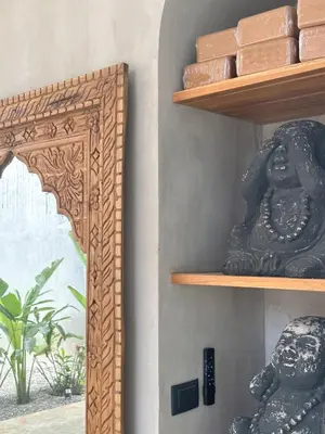 a shelf with a statue next to a mirror at Las chozas I in Tamarindo