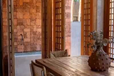 a dining room with a wooden table and a vase on it at Las chozas I in Tamarindo