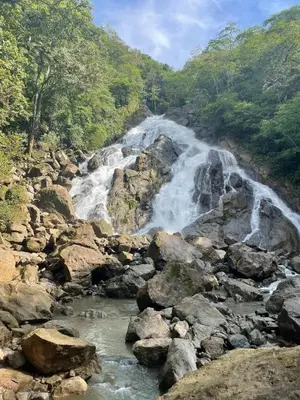 a waterfall on the side of a river with rocks at Refugio del Ocaso - neues Teak-Haus mit Garten in Hojancha