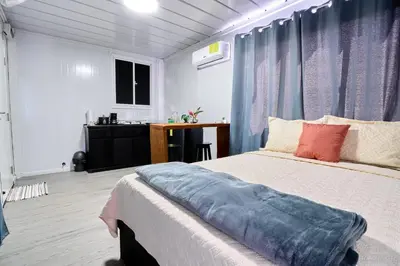 a bedroom with a bed and a desk in it at Módulos Yunni in Uvita