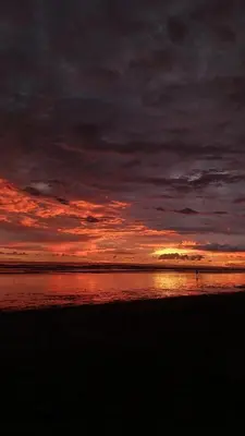 a person walking on the beach at sunset at Módulos Yunni in Uvita