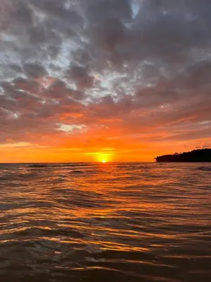 a sunset over a body of water with the sun setting at Módulos Yunni in Uvita