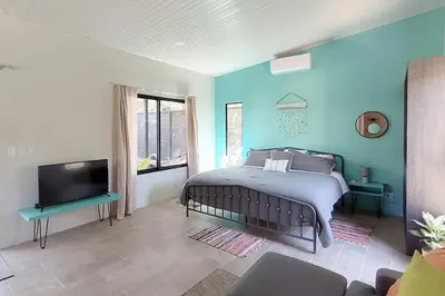 a bedroom with a bed and a flat screen tv at Casa Cosmo Samara in Sámara