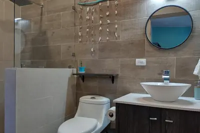 a bathroom with a toilet and a sink and a mirror at Casa Cosmo Samara in Sámara