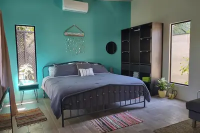 a bedroom with a bed with a blue wall at Casa Cosmo Samara in Sámara