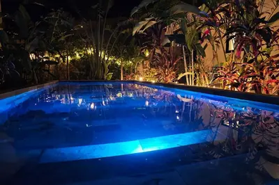 a swimming pool in a garden at night at Casa Cosmo Samara in Sámara