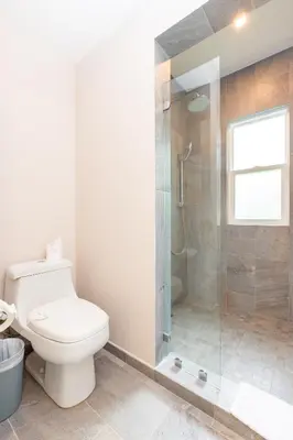 a bathroom with a toilet and a glass shower at Uvita Paradise , Walk to the Ballena Beach in Uvita